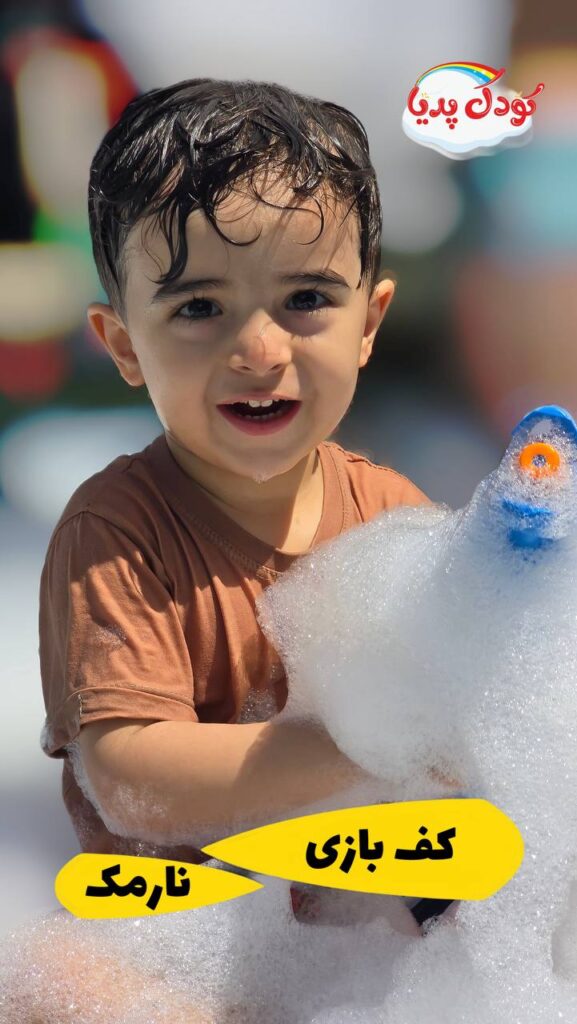 کودک ۵ ساله در حال خندیدن بین کف‌های فستیوال آبی