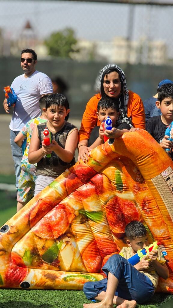بازی گروهی مادر و کودک در کف‌بازی شاد تابستانی